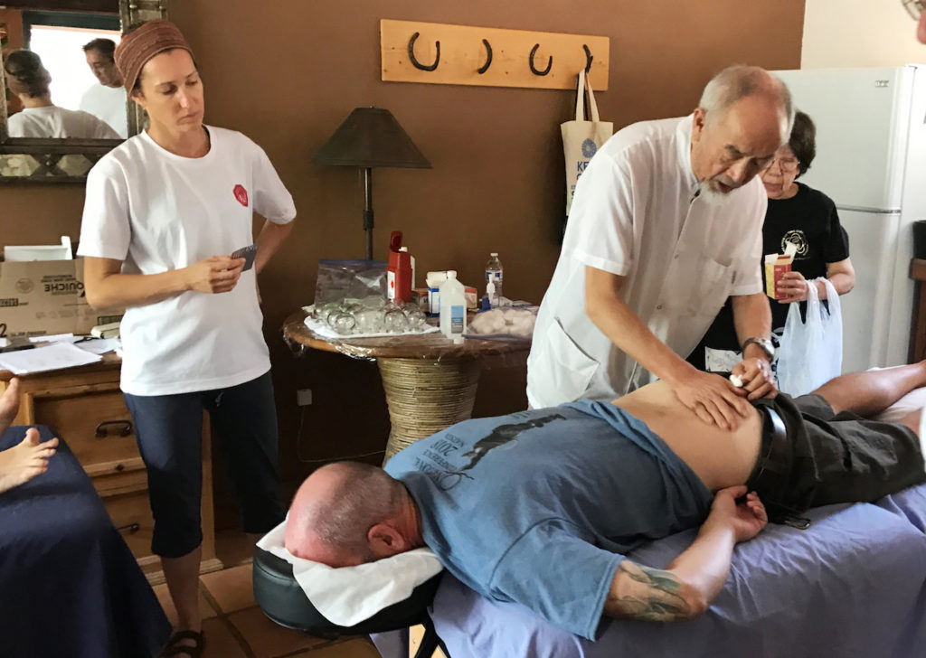 Emile Breton assisting Dr Li as he treats Ethan Murchie with acupuncture